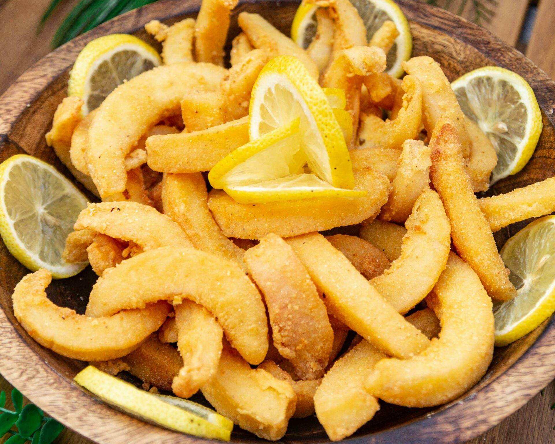 Delicious golden calamari rings with lemon, perfect for a tasty appetizer or snack.